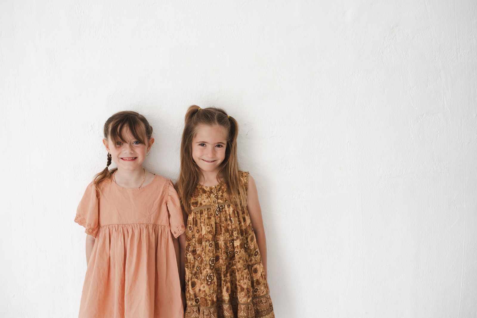 Two young children standing side by side, ready for a big day